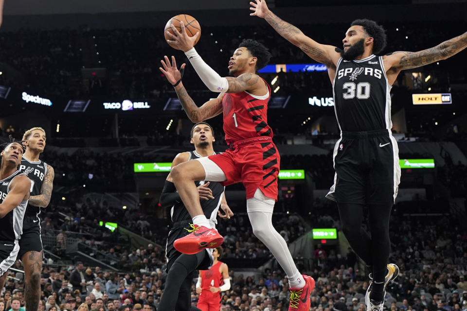 Portland Trail Blazers guard Anfernee Simons (1) drives to the basket past San Antonio Spurs forward Julian Champagnie (30) during the first half of an NBA basketball game in San Antonio, Friday, Jan. 26, 2024. (AP Photo/Eric Gay)