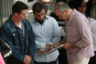 In this April 29, 2019, photo, Cuban migrants are registered by Mexican immigration officials in Ciudad Juarez, Mexico, to be taken across the Paso del Norte International bridge to be processed as asylum seekers on the U.S. side of the border. For Cubans and others, one of the biggest obstacles is getting an opportunity to apply for asylum. (AP Photo/Christian Torres)