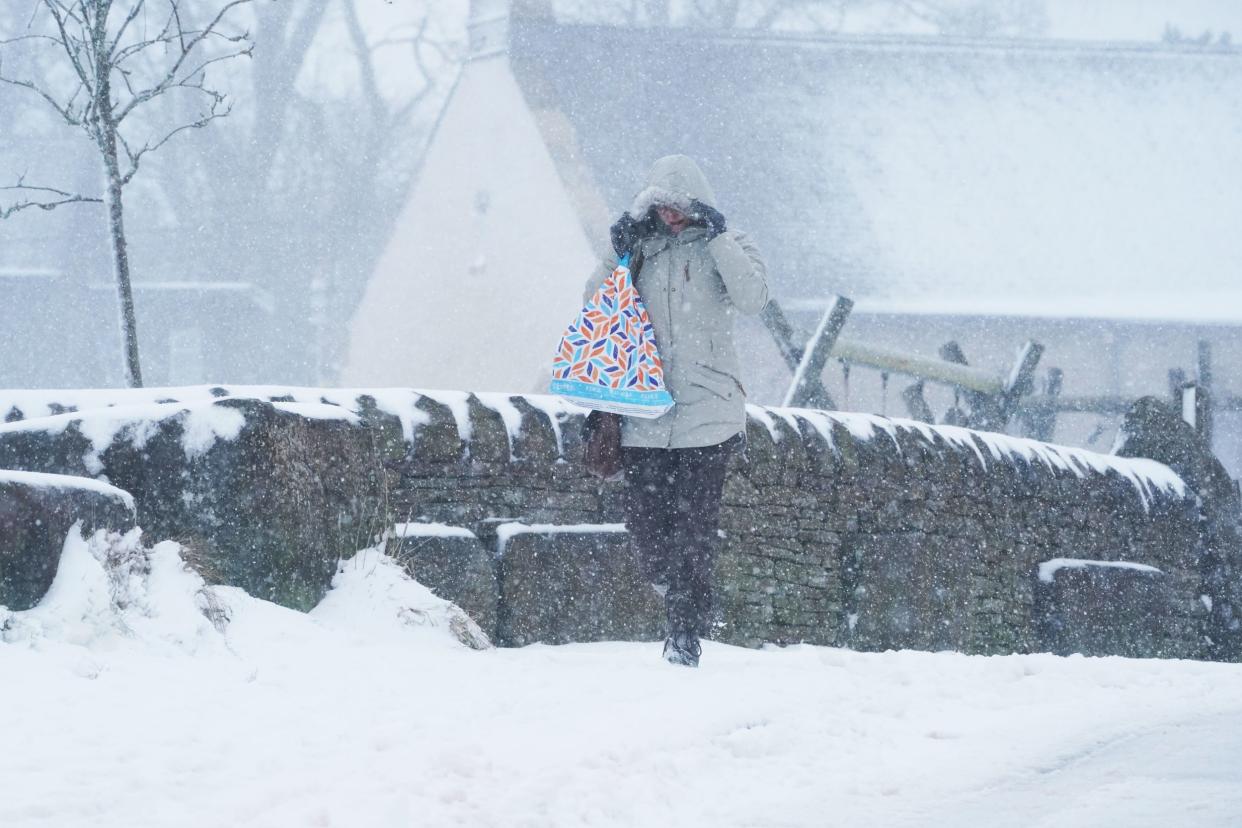 A woman walks through the snow in Nenthead, Cumbria: PA