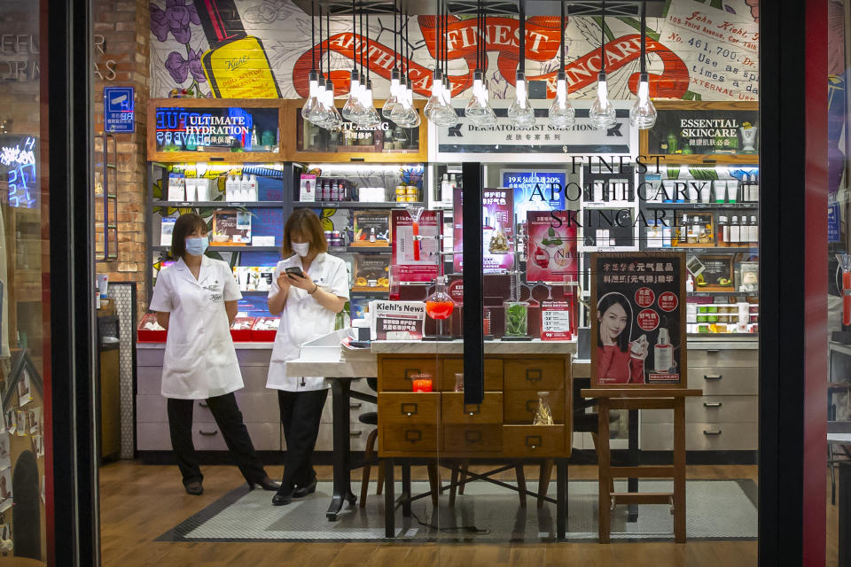 Shop clerks wear face masks to protect against the spread of the new coronavirus as they wait for customers at an outdoor shopping area in Beijing, Saturday, May 9, 2020. North Korean state media reported on Friday that leader Kim Jong Un sent a personal message to Chinese President Xi Jinping to praise what he described as China's success in getting its COVID-19 epidemic under control. (AP Photo/Mark Schiefelbein)