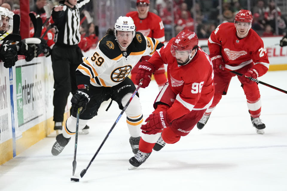 Boston Bruins left wing Tyler Bertuzzi (59) and Detroit Red Wings defenseman Jake Walman (96) chase the puck in the second period of an NHL hockey game Sunday, March 12, 2023, in Detroit. (AP Photo/Paul Sancya)