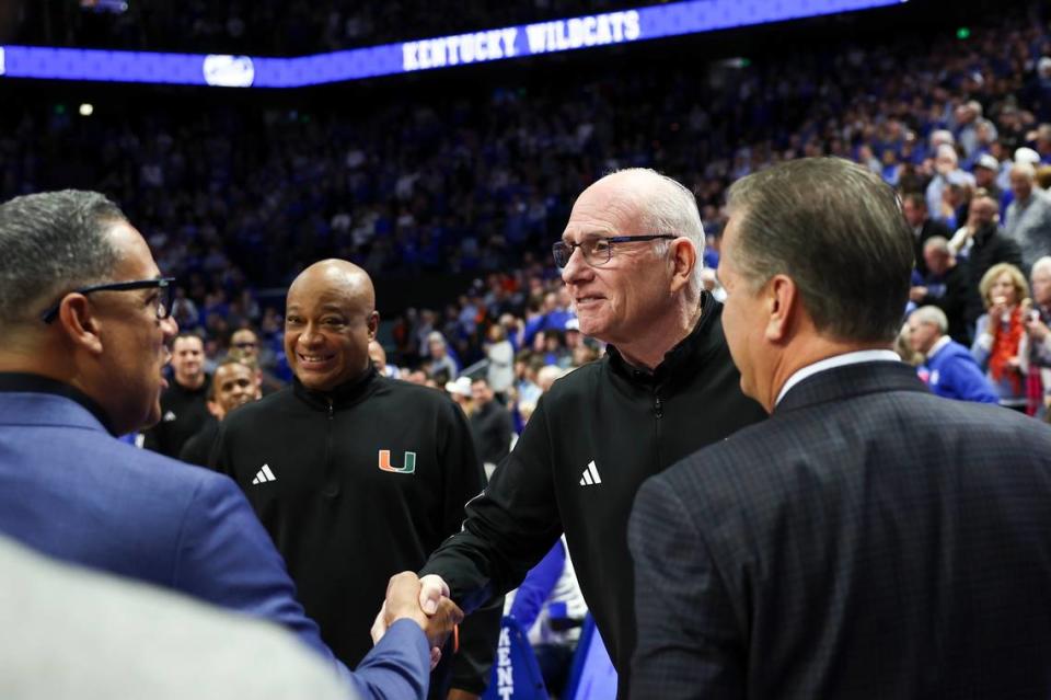 Miami head coach Jim Larranaga, second from right, shakes hands with UK assistant coach Chuck Martin prior to Tuesday’s game at Rupp Arena.