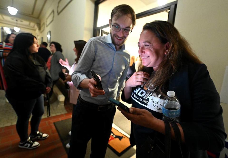 Nicole Sidman, right, and Drew Kromer, left, Mecklenburg County Democratic Party chair, smiles as they look over election results on Tuesday, March 5, 2024. Sidman is running for the North Carolina House District 105 seat. JEFF SINER/jsiner@charlotteobserver.com