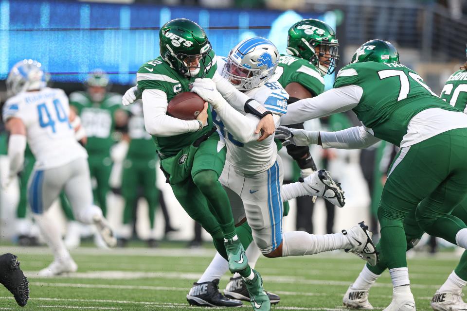 New York Jets quarterback Zach Wilson is sacked by Detroit Lions linebacker Romeo Okwara during the second half at MetLife Stadium, Dec. 18, 2022 in East Rutherford, New Jersey.