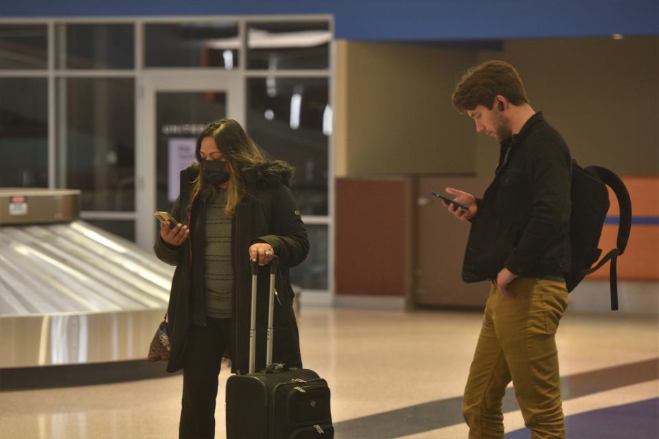 Travelers wait for their luggage after getting in from a Chicago flight Tuesday at the Sioux Falls Regional Airport. Masks are now optional for passengers after the federal mandate was lifted Monday.