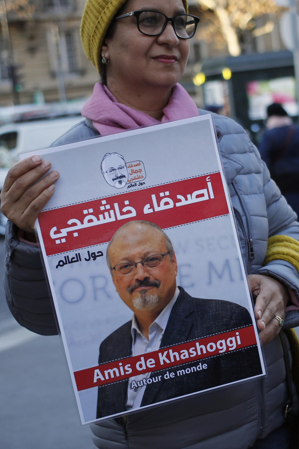 An activist holds a portrait reading "Friends of Khashoggi around the world" as part of a protest closed to the Saudi Arabia embassy, in Paris, Thursday, Oct. 25, 2018. Saudi prosecutors say the killing of journalist Jamal Khashoggi was planned, state-run media reported Thursday, reflecting yet another change in the shifting Saudi Arabian account of what happened to the writer who was killed by Saudi officials in their Istanbul consulate. (AP Photo/Francois Mori)