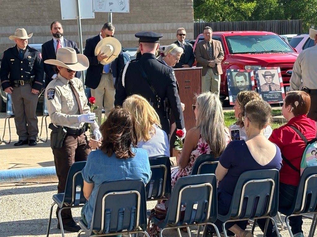 Officers of Taylor County Sheriff's Office, the Texas Department of Public Safety and Abilene Police Department give red roses to loved ones of fallen officers to honor their sacrifice and service at the annual memorial ceremony Wednesday.