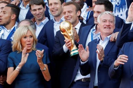 FILE PHOTO: French President Emmanuel Macron and his wife Brigitte Macron pose with France soccer team captain Hugo Lloris and coach Didier Deschamps and players before a reception to honour the France soccer team after their victory in the 2018 Russia Soccer World Cup, at the Elysee Palace in Paris, France, July 16, 2018. REUTERS/Philippe Wojazer