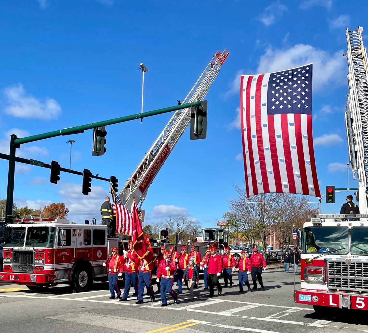 Military units march at the start of the parade at Grove and North streets.