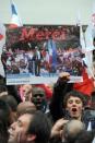 A supporter of Socialist Party (PS) newly elected French President holds a party poster on May 6, 2012 outside the party's headquarters following the announcement of the estimated results of the second round of Presidential election