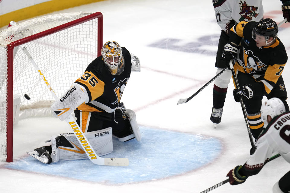 Arizona Coyotes' Lawson Crouse, bottom right, gets a shot past Pittsburgh Penguins goaltender Tristan Jarry (35) for a goal during the first period of an NHL hockey game in Pittsburgh, Tuesday, Dec. 12, 2023. (AP Photo/Gene J. Puskar)