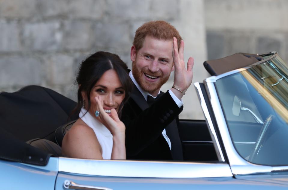 Britain’s Prince Harry, Duke of Sussex and Meghan Markle, Duchess of Sussex, leave Windsor Castle in Windsor in an E-Type Jaguar after their wedding to attend an evening reception at Frogmore House. STEVE PARSONS/AFP/Getty Images