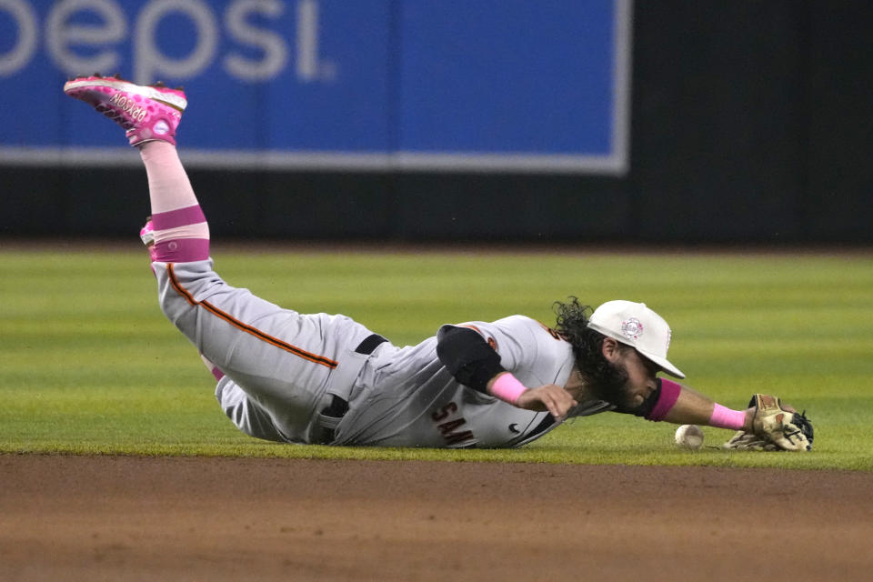 San Francisco Giants shortstop Brandon Crawford dives for a ball hit by Arizona Diamondbacks' Gabriel Moreno in the fifth inning during a baseball game, Sunday, May 14, 2023, in Phoenix. (AP Photo/Rick Scuteri)