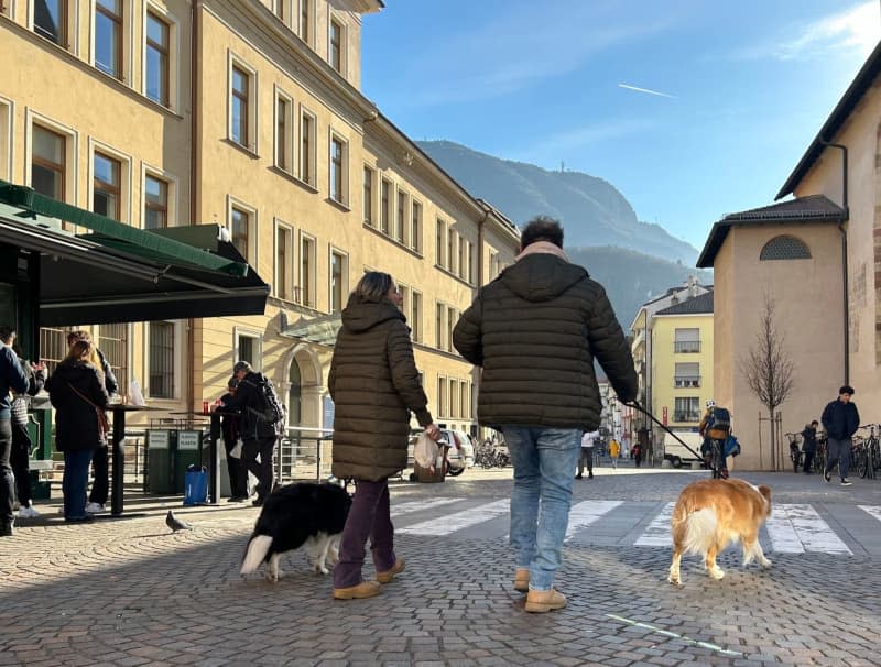 Dog owners on a walk through the streets of South Tyrol's capital Bolzano. Christoph Sator/dpa