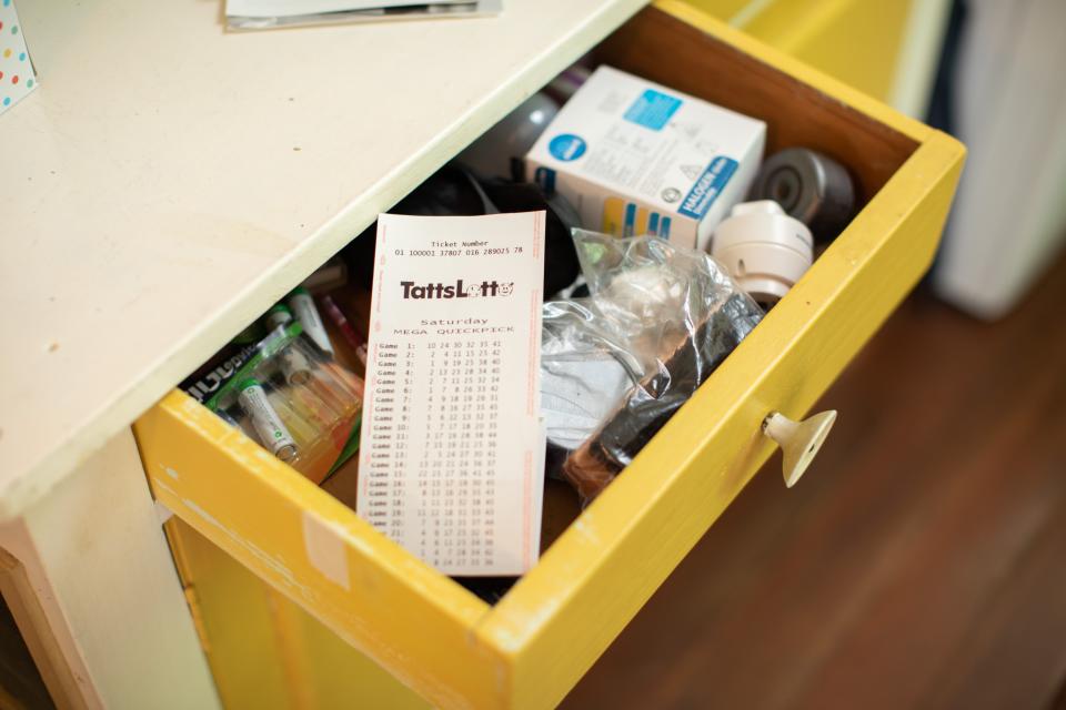 A TattsLotto ticket sits in a drawer.