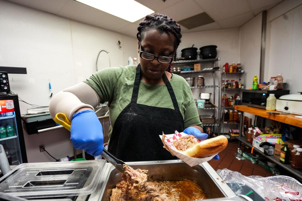 Trecia Leachmon prepares a pulled pork sandwich at Leachmon's Pit Stop BBQ in Valley West Mall.