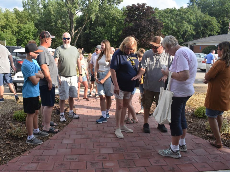 People check out the newly unveiled brick walk in Deerfield's community park Friday during the first of the village's two-day sesquicentennial celebration. The brick walk is designed to commemorate a family’s history in Deerfield.