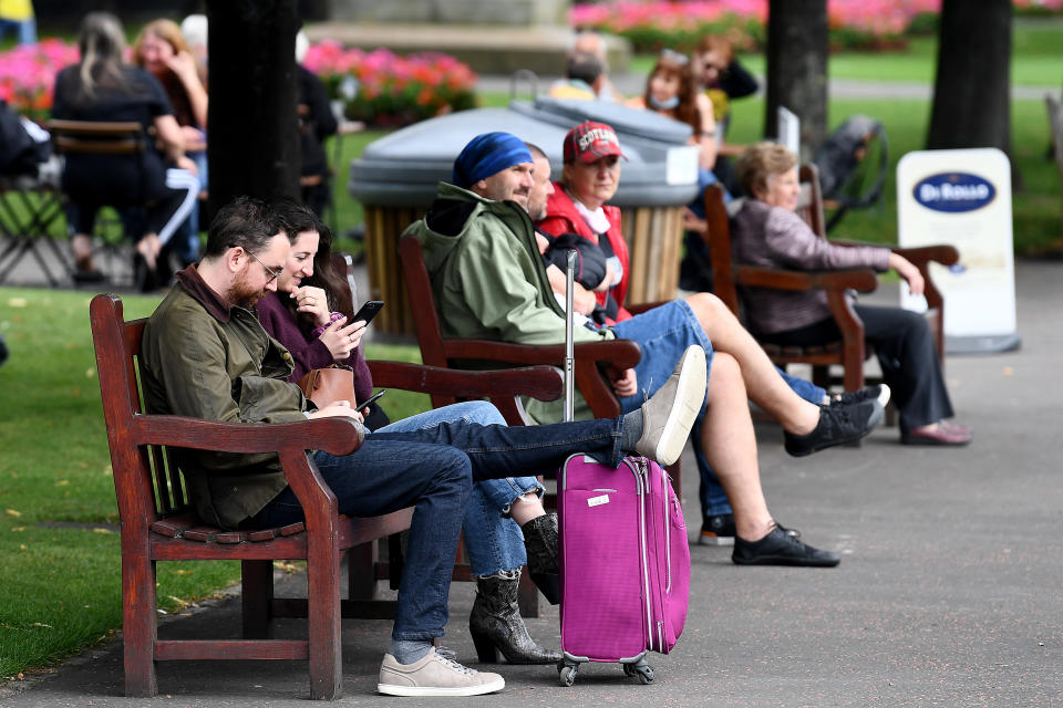 EDINBURGH, SCOTLAND - SEPTEMBER 14: Members of the public sit on park benches as a new law comes into force limiting social gatherings to a maximum of six people from two households on September 14, 2020 in Edinburgh, Scotland. The country joined England in imposing a six-person limit on indoor and outdoor gatherings to curb a rise in Covid-19 infections. (Photo by Jeff J Mitchell/Getty Images)