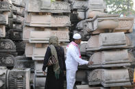 Indian Muslims look at pillars lying at a workshop for the construction of a Rama temple ahead of its groundbreaking ceremony in Ayodhya, in the Indian state of Uttar Pradesh, Monday, Aug. 3, 2020. As Hindus prepare to celebrate the groundbreaking of a long-awaited temple at a disputed ground in northern India, Muslims say they have no firm plans yet to build a new mosque at an alternative site they were granted to replace the one torn down by Hindu hard-liners decades ago. (AP Photo/Rajesh Kumar Singh)