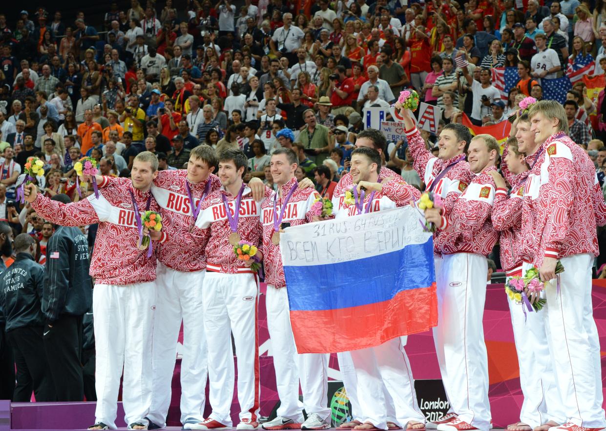 Russian players pose on the podium after winning the bronze medal in the London 2012 Olympic Games men's basketball competition at the North Greenwich Arena in London on August 12, 2012. The US won the gold medal followed by the silver to Spain and the bronze to Russia. AFP PHOTO /MARK RALSTON        (Photo credit should read MARK RALSTON/AFP/GettyImages)
