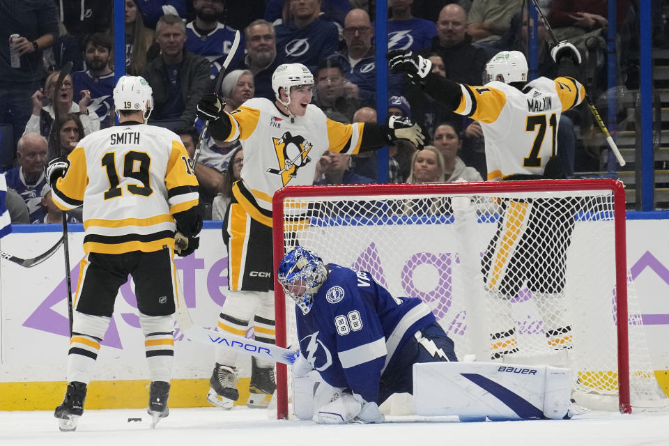 Pittsburgh Penguins left wing Drew O'Connor (10) celebrates with center Evgeni Malkin (71) and =right wing Reilly Smith (19) after scoring past Tampa Bay Lightning goaltender Andrei Vasilevskiy (88) during the second period of an NHL hockey game Thursday, Nov. 30, 2023, in Tampa, Fla. (AP Photo/Chris O'Meara)