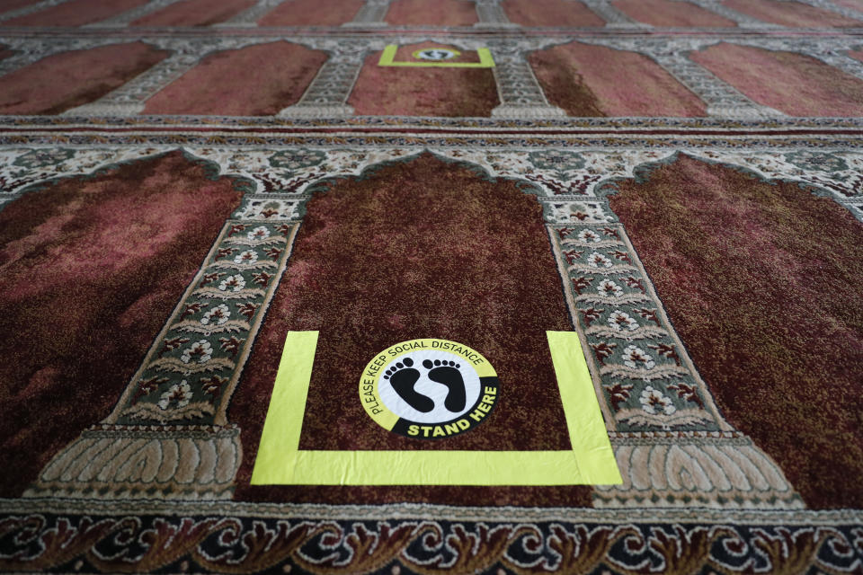 Social distance markers are seen Wednesday, April 7, 2021 in the prayer room of the Maine Muslim Community Center in Portland, Maine. Ahead of Ramadan, Islamic leaders are using social media, virtual town halls and face-to-face discussions to spread the word that it’s acceptable for Muslims to be vaccinated during daily fasting that happens during the holy month. (AP Photo/Joel Page)