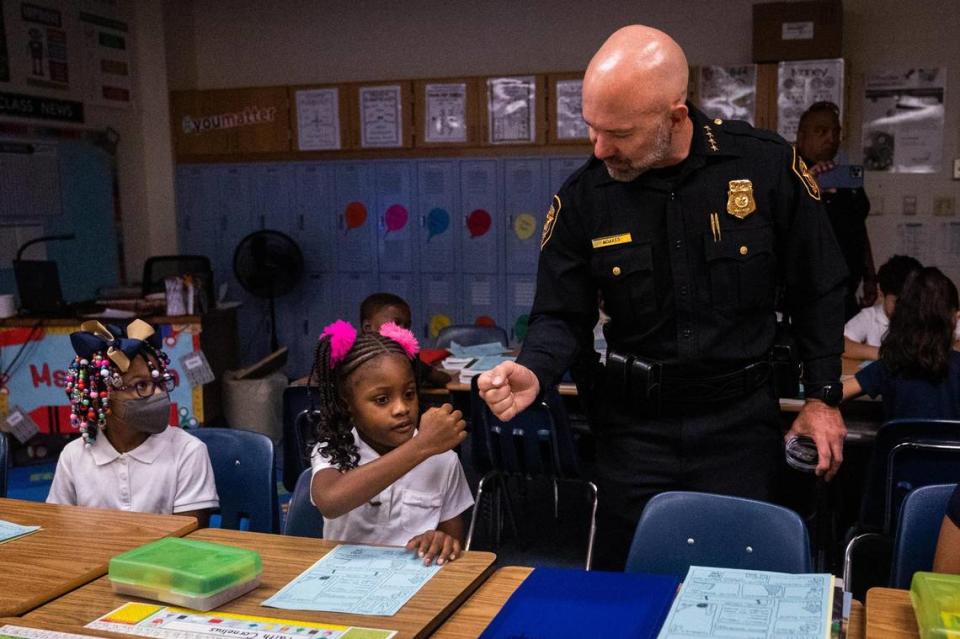 Fort Worth Police Chief Neil Noakes fist bumps Faith Cornelius as classes commence on the first day of school Monday. The Fort Worth Police Department worked with the district to enhance security training over the summer.