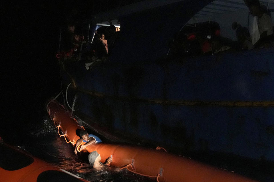 Migrants in the sea wait to be rescued from Spanish NGO Open Arms lifeguard during a rescue operation at the Mediterranean sea, early Sunday, Sept. 18, 2022. Around 200 migrants from Syria and Africa countries were rescued by NGO Open Arms crew members. (AP Photo/Petros Karadjias)