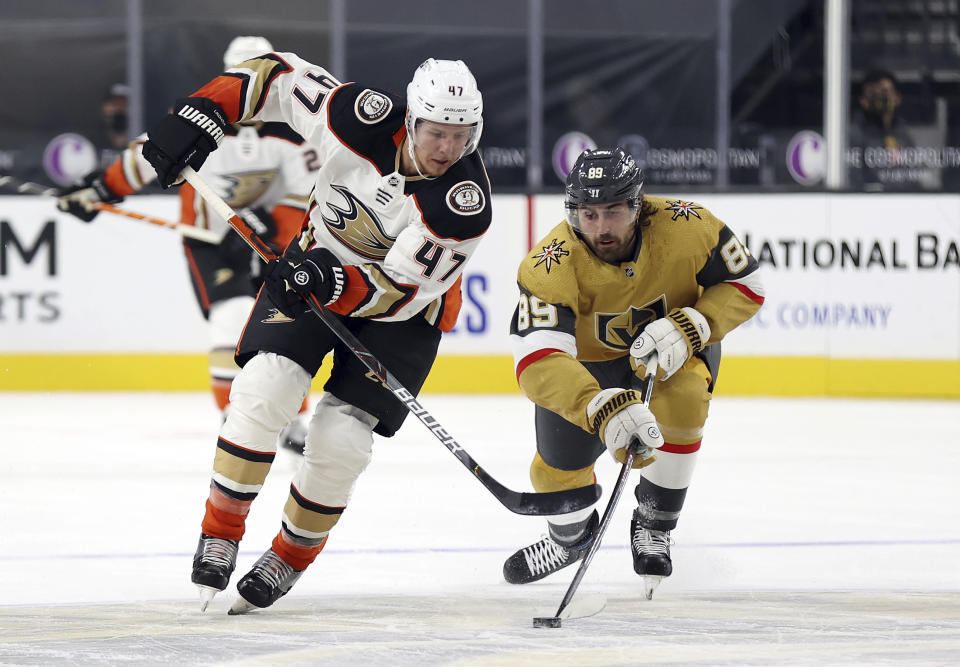 Vegas Golden Knights right wing Alex Tuch (89) steals the puck from Anaheim Ducks defenseman Hampus Lindholm (47) during the first period of an NHL hockey game Saturday, Jan. 16, 2021, in Las Vegas. (AP Photo/Isaac Brekken)