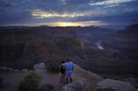 FILE - Alyssa Chubbuck, left, and Dan Bennett embrace while watching the sunset at Guano Point overlooking the Colorado River on the Hualapai reservation Monday, Aug. 15, 2022, in northwestern Arizona. Competing priorities, outsized demands and the federal government's retreat from a threatened deadline all combined to thwart a voluntary deal last summer on how to drastically cut water use from the parched Colorado River, according to emails obtained by The Associated Press. (AP Photo/John Locher)