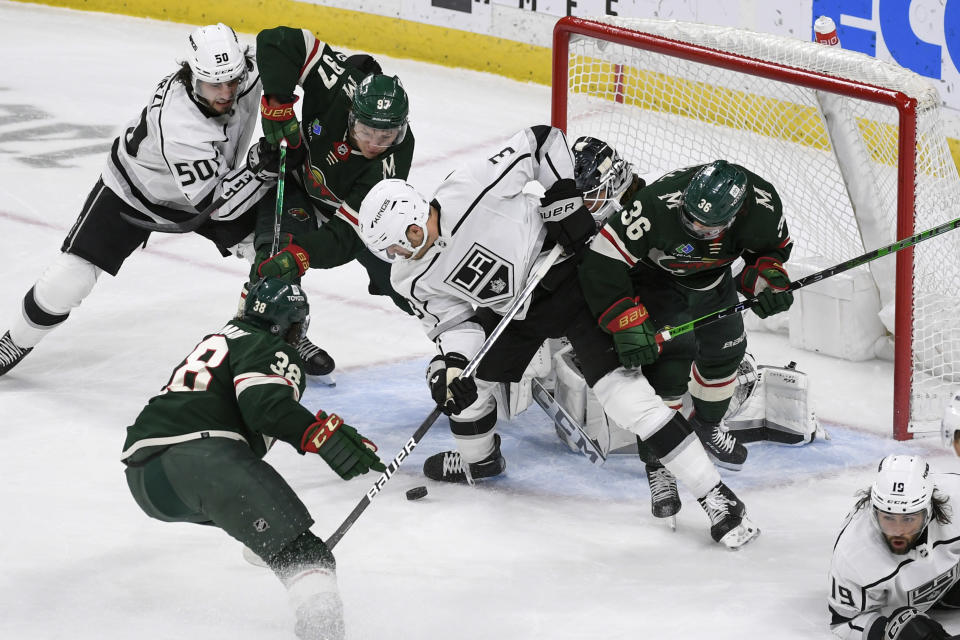 Los Angeles Kings defenseman Matt Roy, center, and defenseman Sean Durzi (50) try to clear the puck from the goal as Minnesota Wild right wing Mats Zuccarello (36), left wing Kirill Kaprizov (97) and right wing Ryan Hartman try to score during the first period of an NHL hockey game Tuesday, Feb. 21, 2023, in St. Paul, Minn. (AP Photo/Craig Lassig)
