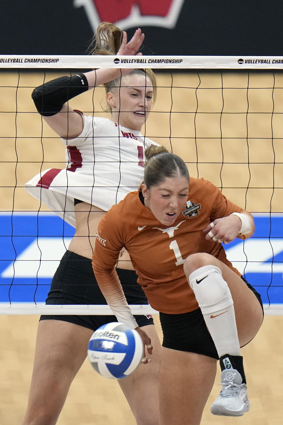 Wisconsin's Anna Smrek (14) scores against Texas's Ella Swindle (1) during a semifinal match in the NCAA Division I women's college volleyball tournament Thursday, Dec. 14, 2023, in Tampa, Fla. (AP Photo/Chris O'Meara)