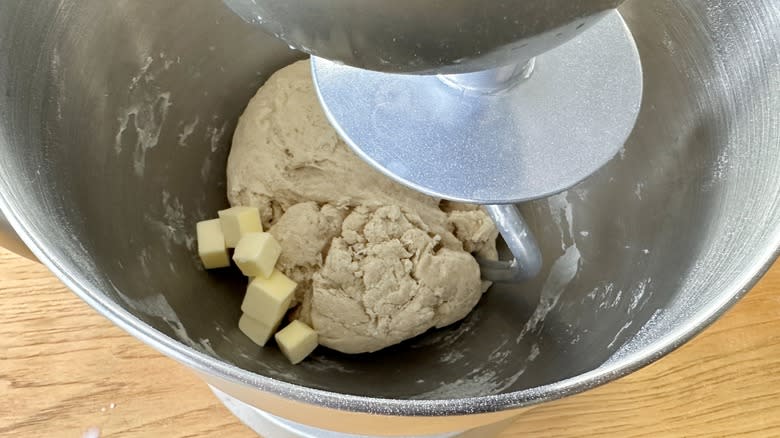 Adding butter to dough in mixer