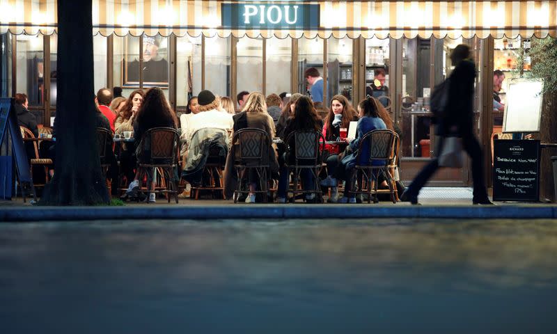People sit in a outside restaurant, as France's Prime Minister announced to close most all non-indispensable locations, notably cafes, restaurants, cinemas, nightclubs and shops from midnight on Saturday, In Paris