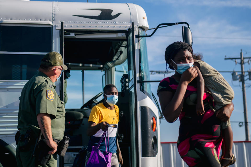 Migrants exit a Border Patrol bus and prepare to be received by the Val Verde Humanitarian Coalition after crossing the Rio Grande on September 22, 2021 in Del Rio, Texas. / Credit: BRANDON BELL / Getty Images