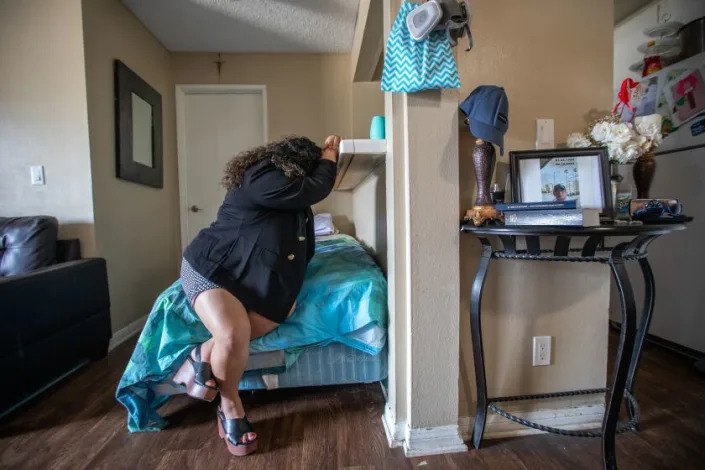  Ruth Lopez&#39;s brother Juan Lopez, 39, was shot to death last month as he painted over gang graffiti on the wall of a business. Ruth is sitting on his bed in her living room near a small memorial table with his photo, hat, sunglasses, his watch, a Mormon Bible, and flowers on Monday, May 22, 2023, in Reseda, CA. Ruth stated her brother was humble, quiet, hard-working, a good father, and a good friend. (Francine Orr / Los Angeles Times)