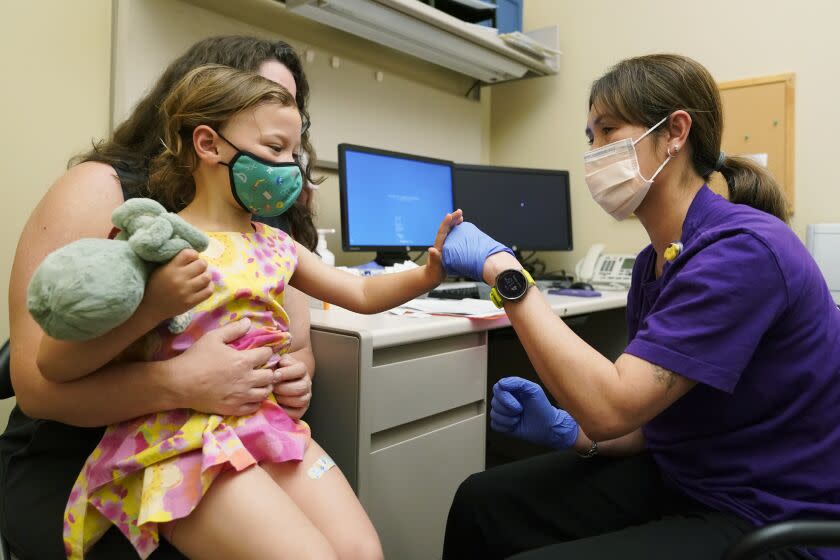 Nora Burlingame, 3, gives a fist-bump to nurse Luann Majeed after getting a Pfizer COVID-19 vaccine shot.