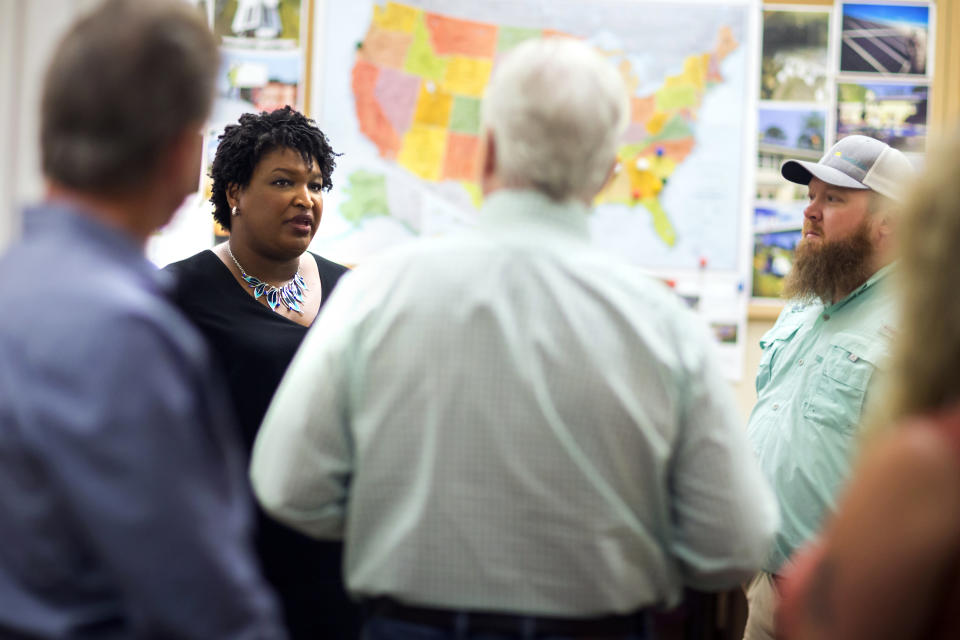 Georgia Democratic gubernatorial candidate Stacey Abrams, left, meets with a group of employees at the Coastal Solar office during a campaign stop to announce her "Jobs for Georgia Plan", Thursday, July 26, 2018, in Hinesville, Ga. (AP Photo/Stephen B. Morton)