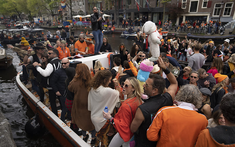 Orange-clad people celebrate King’s Day in Amsterdam on April 27. After two years of celebrations muted by coronavirus lockdowns, the Netherlands marked the 55th birthday of King Willem-Alexander of the House of Orange with street parties, music festivals and a national poll showing trust in the monarch ebbing away. <em>Associated Press/Peter Dejong</em>