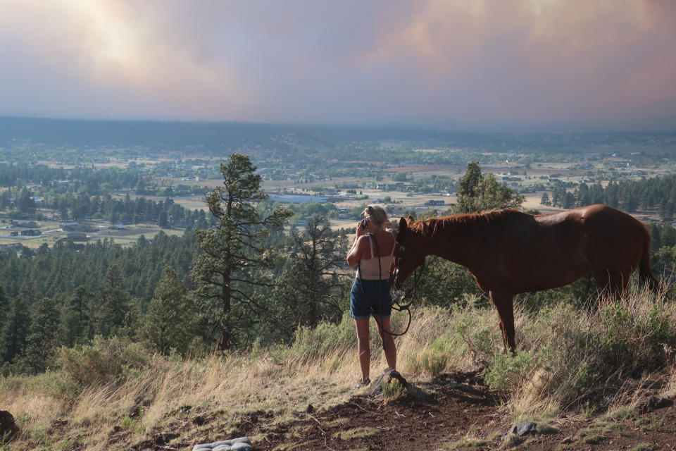 Image: A person watches as smoke rises above neighborhoods on the outskirts of Flagstaff, Ariz., on  June 12, 2022. (Felicia Fonseca / AP)