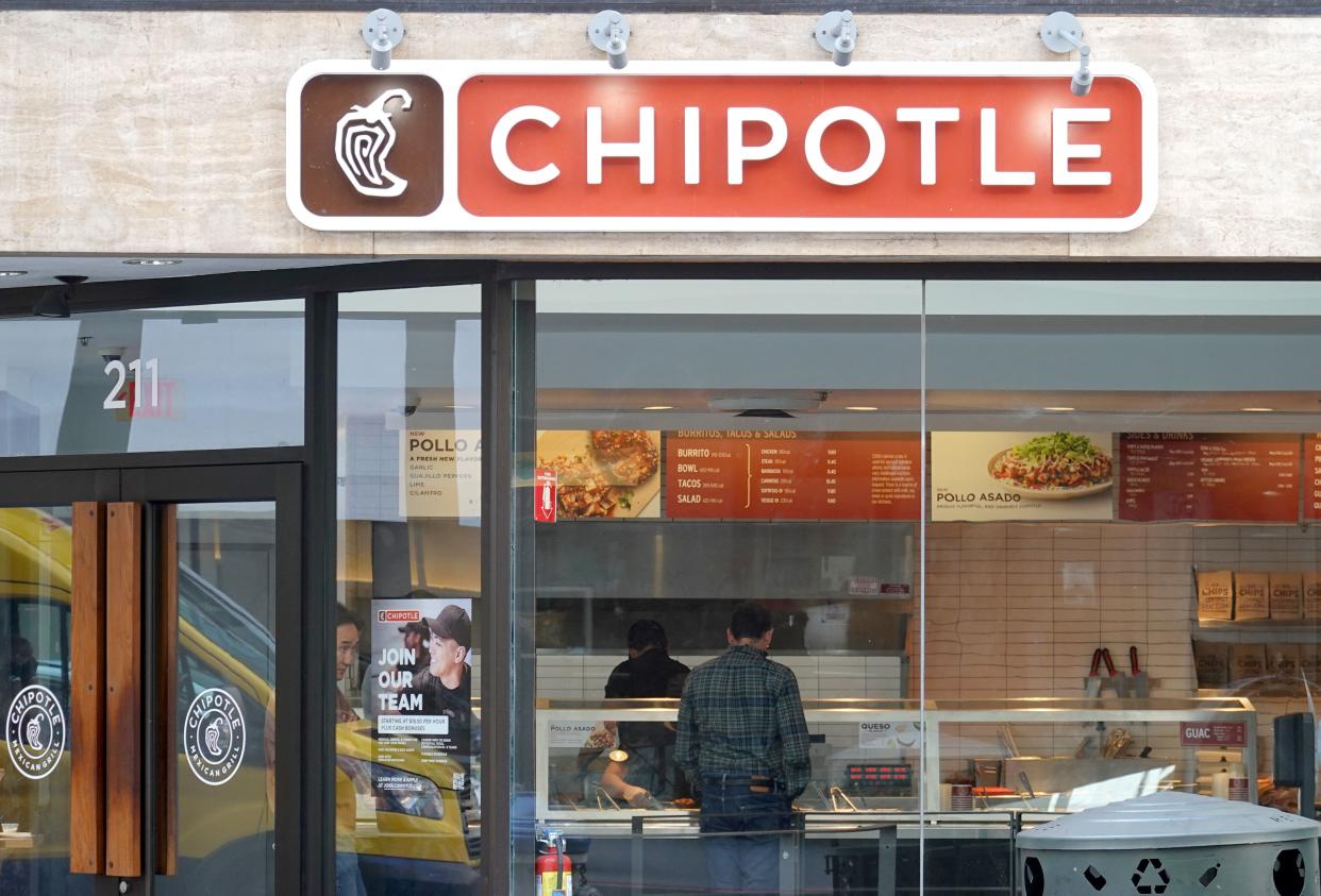 A customer orders food at a Chipotle restaurant.