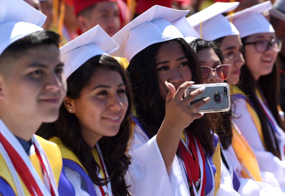 Lakewood High School students singing the alma mater during the graduation ceremony at Veterans Memorial Stadium in Long Beach on Wednesday, June 12, 2019.