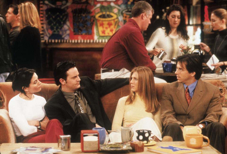 Monica, Chandler, Rachel, and her date sitting on the couch at Central Perk on "Friends"