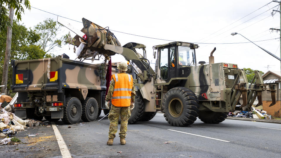 A supplied image obtained on Tuesday, March 8, 2022, of ADF personnel removing flood-damaged belongings from streets in Lismore, New South Wales.