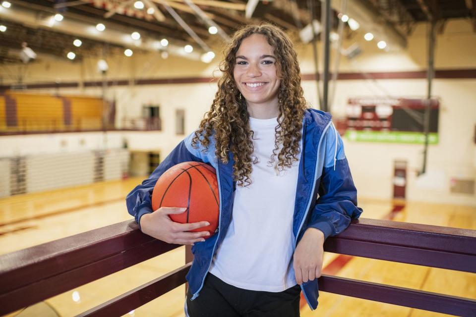 portrait of female high school basketball player in gymnasium