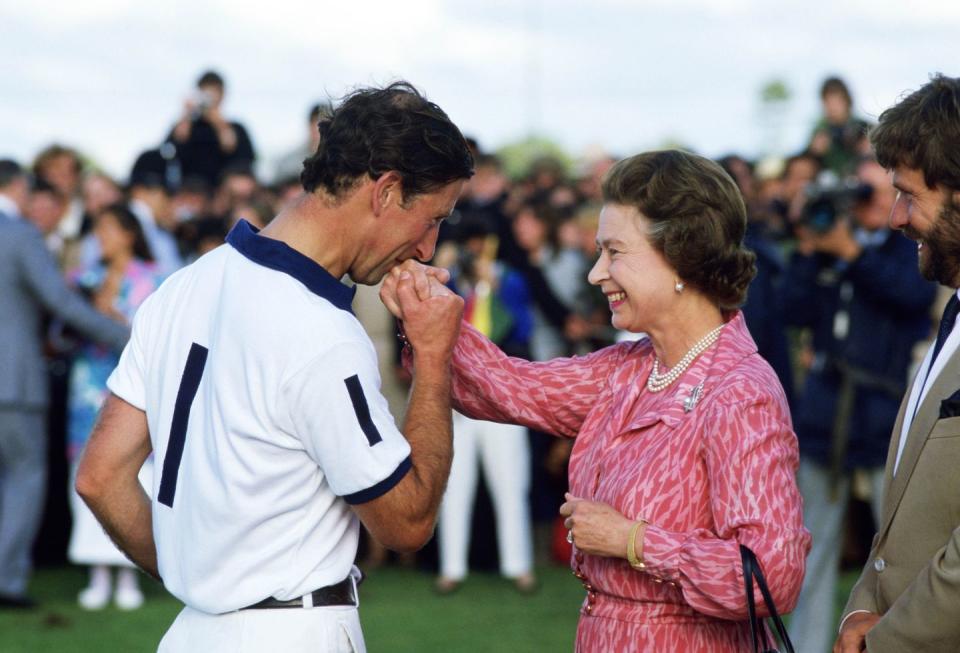 prince charles kisses the hand of his mother, queen elizabet