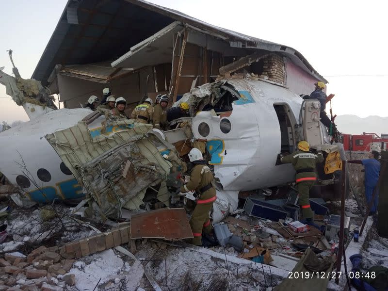 Emergency and security personnel are seen at the site of the plane crash near Almaty