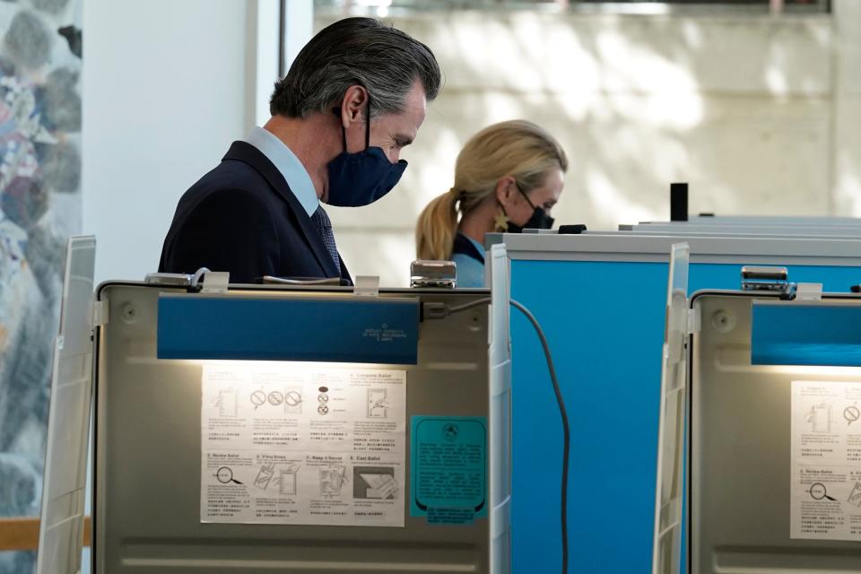 California Gov. Gavin Newsom, and his wife First Partner Jennifer Siebel Newsom mark their ballots at a voting center in Sacramento, Calif., Friday, Sept. 10, 2021.