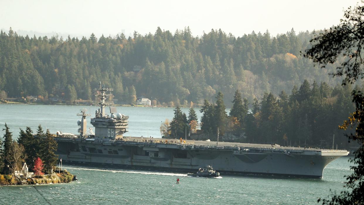 The USS Nimitz moves through a hazy Rich Passage as it returns to Naval Base Kitsap-Bremerton on Tuesday.