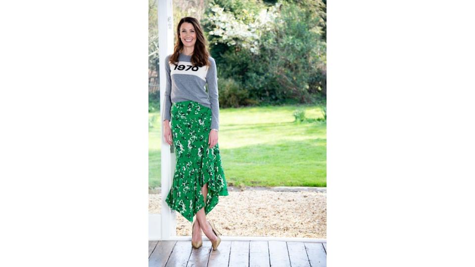 Rosie Green journalist posing on porch wearing green floral skirt